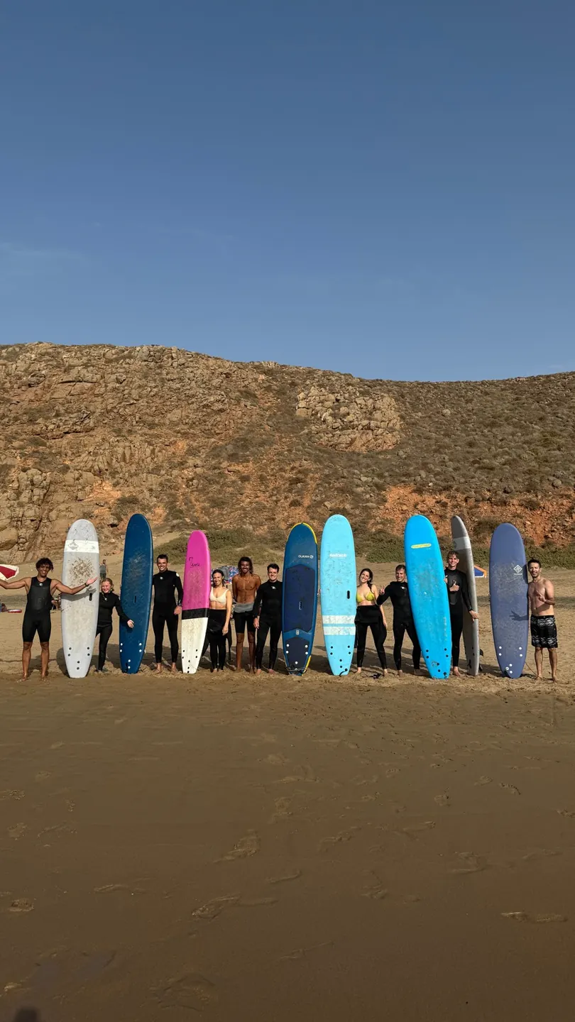Surfers holding colourful boards on the beach