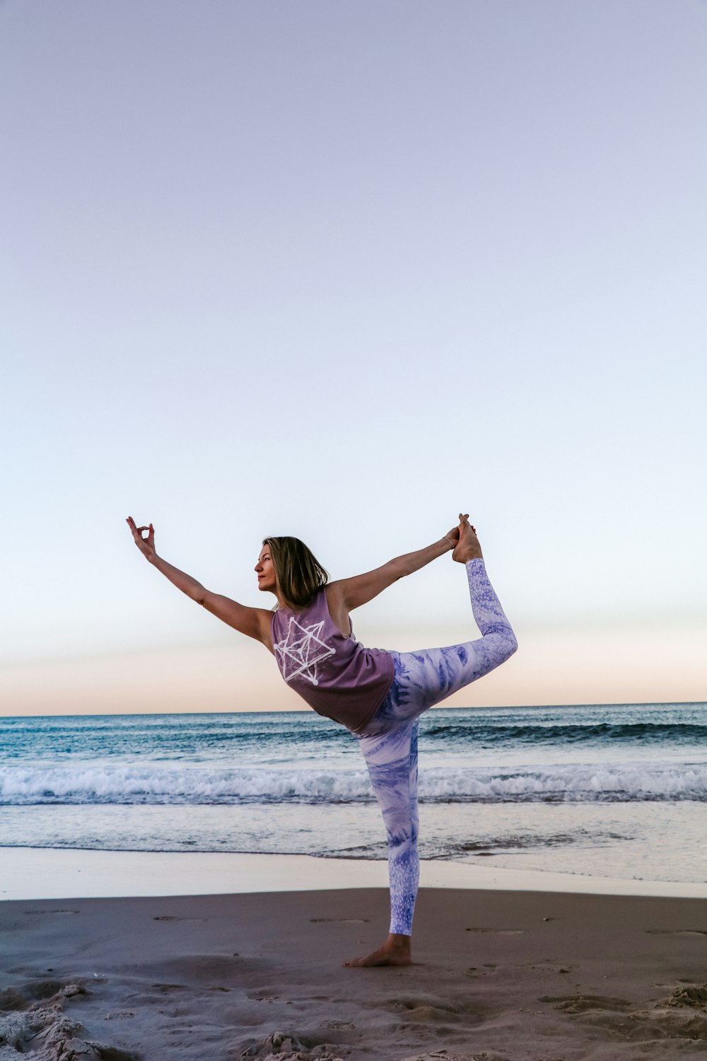 Woman practising yoga on a beach